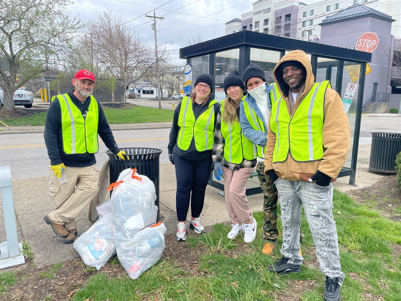Volunteers in high visibility vests clean litter in downtown Covington as part of the Covington Clean and Safe Initiative